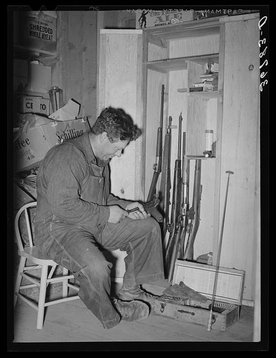George Hutton Jr. looking over his guns. Pie Town, New Mexico