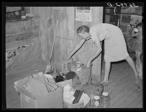 Mrs. Faro Caudill packing up kitchen equipment for moving to new dugout nearer the well. Notice the pressure cooker. These homesteaders say that the pressure cooker should be put on the national flag for they think it's saving the farm folks for America. Pie Town, New Mexico