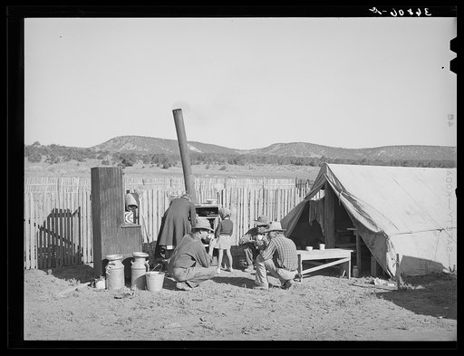 The Caudills are camping out while moving their dugout nearer their water supply, garden and stock lot. These men are neighbors having a cup of coffee before helping Faro rebuild his dugout. Pie Town, New Mexico
