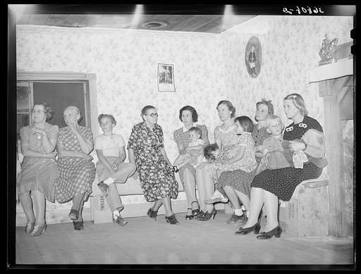 Spectators at the square dance. Women and small children sit on one side of the room, the men and older boys on the other. Pie Town, New Mexico
