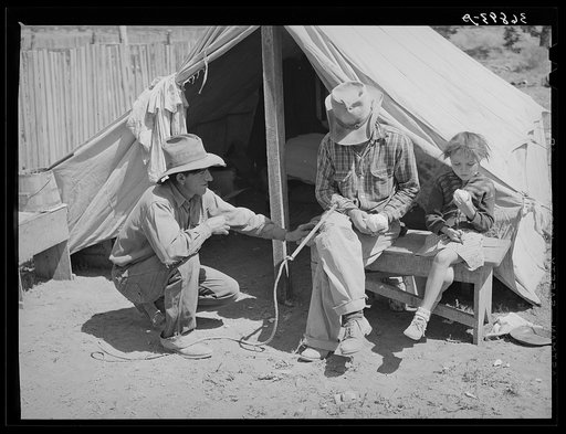 Faro Caudill, left, John Adams, center, and Josie Caudill, right, in front of the Caudill tent in which they are living for a few days while moving the dugout. Pie Town, New Mexico