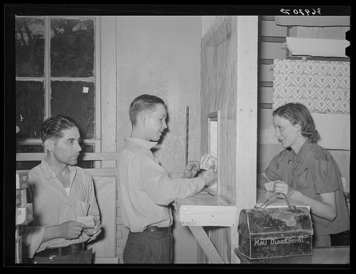 Young miner cashing check at commissary while another waits in line for his turn. Mogollon, New Mexico