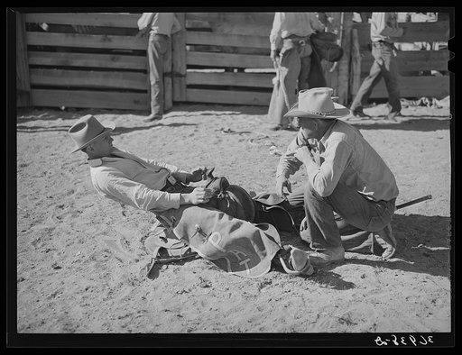 Cowboy testing length of stirrups before bronc busting. Quemado, New Mexico