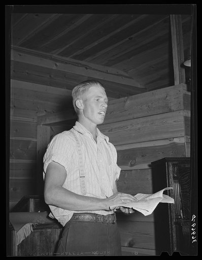 Young farm boy leading community sing. Pie Town, New Mexico