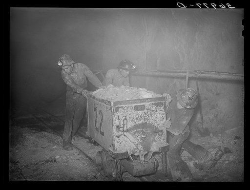 Pushing a car load of gold ore along track in mine. Mogollon, New Mexico