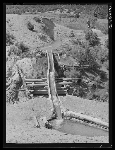 Hollowed-out logs used for transporting irrigation waters across ditch. Trampas, New Mexico