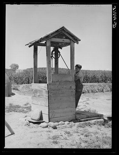 Spanish-American boy drawing water from well. Chamisal, New Mexico