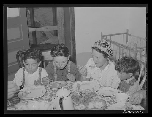 Spanish-American family eating dinner. Chamisal, New Mexico