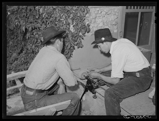 Spanish-American boy sharpening knife. Chamisal, New Mexico