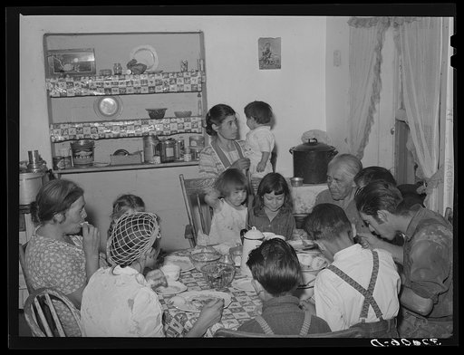 Spanish-American family eating dinner. Chamisal, New Mexico