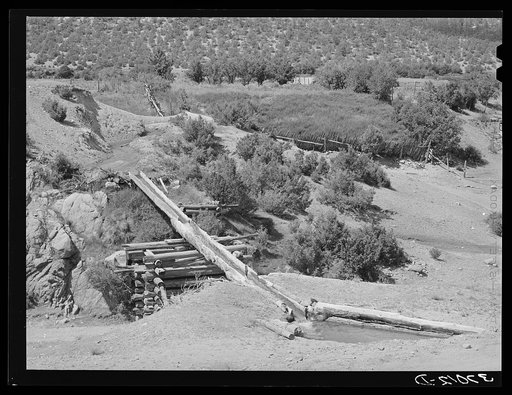 Irrigation water crossing ditch in hollowed out log. Trampas, New Mexico