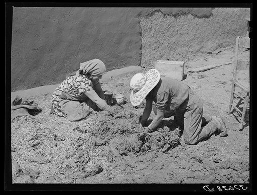 Untitled photo, possibly related to: Mixing straw with mud to make the plaster which is used to replaster the houses once a year. Chamisal, New Mexico