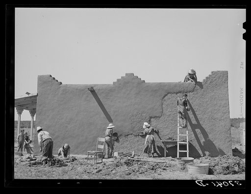 Untitled photo, possibly related to: Spanish-American women replastering an adobe house. This is done once a year. Chamisal, New Mexico