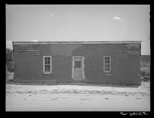 Front of Spanish-American house, Penasco, New Mexico. Notice the small windows, however; because of the brilliant suns in this section, the interiors of the houses are not dark and drab, rather the light seems pleasant and subdued