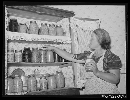 Wife of Spanish-American farmer with canned fruit and vegetables. Chamisal, New Mexico