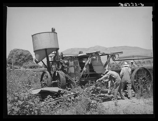 Farmers moving combine. Box Elder County, Utah