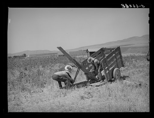 Unloading FSA (Farm Security Administration) cooperative ditcher from trailer. Box Elder County, Utah