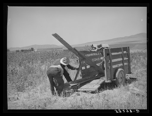 Unloading FSA (Farm Security Administration) cooperative ditcher from trailer. Box Elder County, Utah