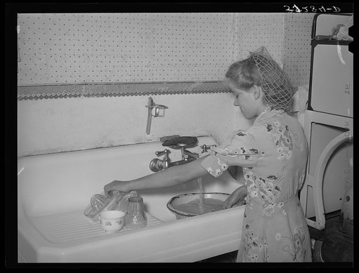 Daughter of Mormon farmer washing dishes. In most of the Mormon communities running culinary water is common. Snowville, Utah