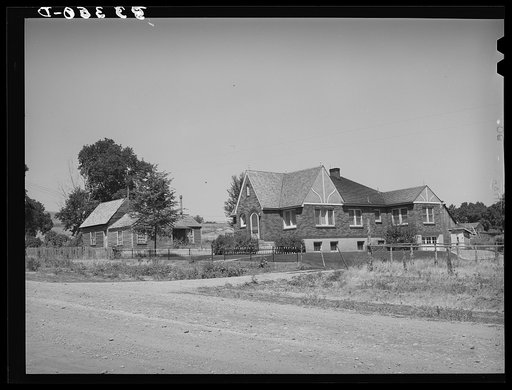 Houses belonging to a Mormon farmer in Mendon, Utah. The new house was built with profits from his farm