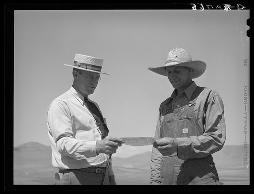 Mr. Thayne, FSA (Farm Security Administration) cooperative specialist, giving a check to one of the Ericson brothers with which to buy a cooperative tractor. Box Elder County, Utah