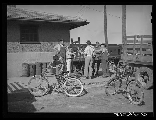 Distributing newspapers to newsboys at the railroad station. Montrose, Colorado
