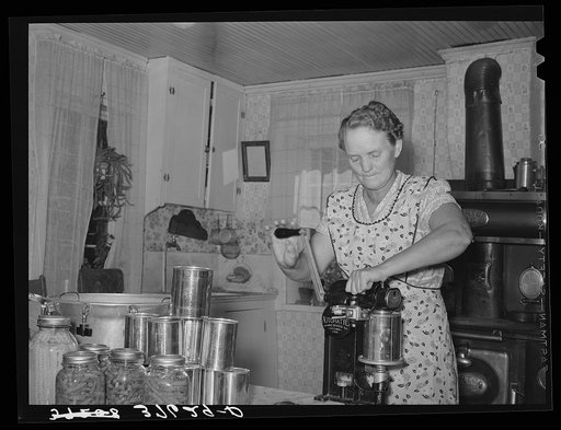 Mrs. Christiansen of the Christiansen canning unit sealing cans. During 1939 she canned 2300 quarts which included 20 mutton, 2 beeves, 5 pigs. Fish was tried very successfully. In this cooperative agreement, there were twenty-five users and outside of the cooperative there were ten others who used 
