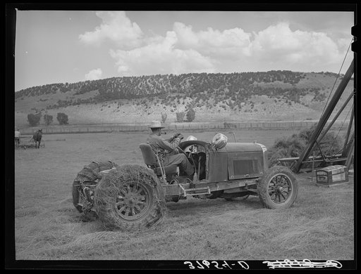 Homemade tractor made of old Lincoln car which is now lifting power for hay stacker. Ouray County, Colorado