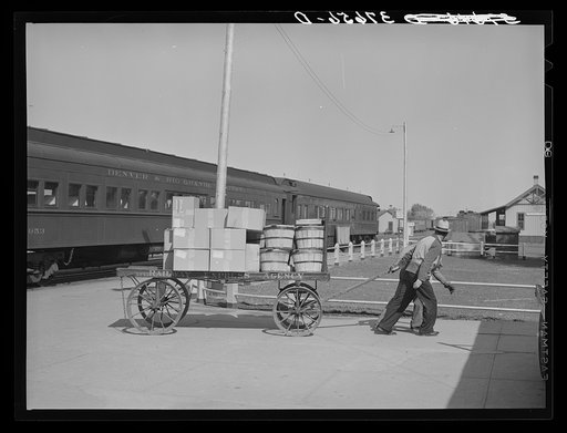 Pulling carload of express packages away from train immediately after the arrival of the morning train. Montrose, Colorado