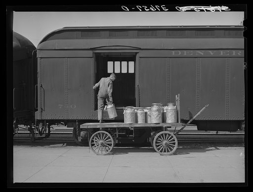 Unloading cans of milk from early morning train. Montrose, Colorado