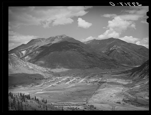 Silverton, Colorado lies in a valley at 9400 feet elevation. This has been a center for mining and milling operations and the tailing-choked Animas River can be seen at left