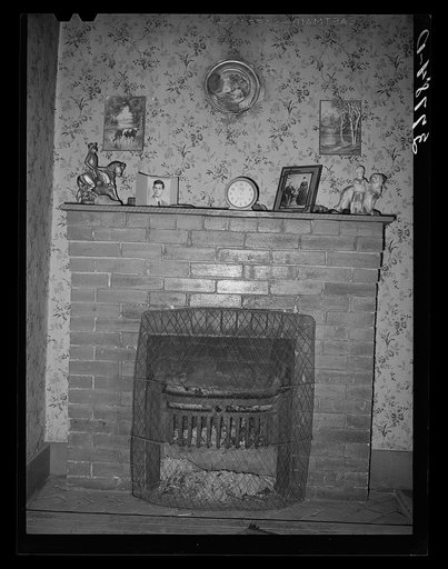 Fireplace in home of farmer living in the Animas River Valley. La Plata County, Colorado