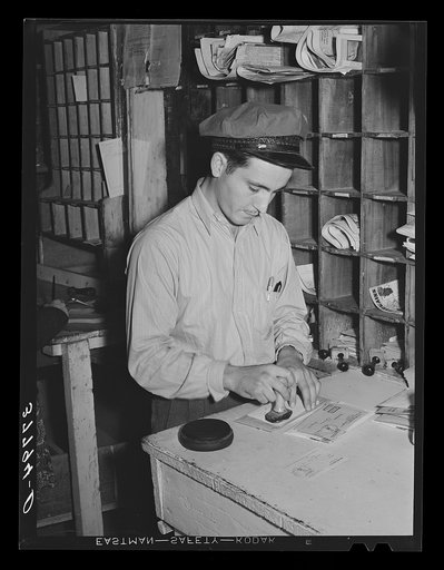 Untitled photo, possibly related to: Postmaster cancelling stamps. Concho, Arizona