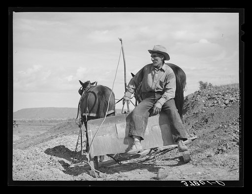 Worker of Concho, Arizona, sitting on a stoop