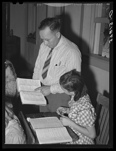 School teacher pointing out a word to grade school pupil, Santa Clara, Utah. See general caption