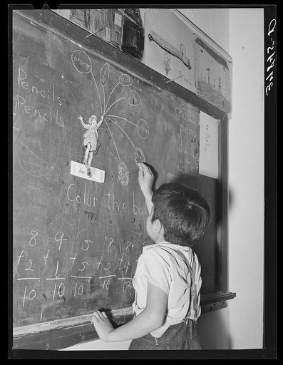 Grade school pupil at blackboard. Concho, Arizona