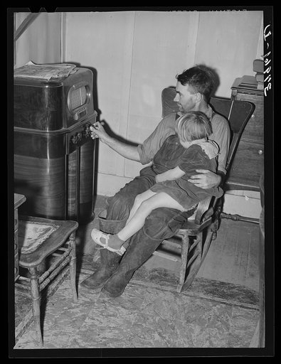 John Frost and daughter listening to radio in their home. Tehama County, California