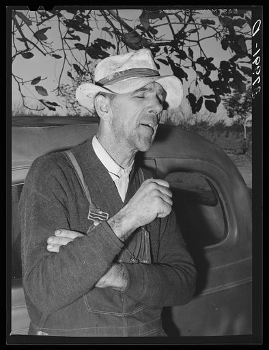 Untitled photo, possibly related to: Paul Erickson, owner of forty acres of land in Yuba County, California. He is working on his tractor. He has diversified fruit farm with a federal land bank loan and production credit loan. He does as much of his own pruning, thinning and picking as possible and 