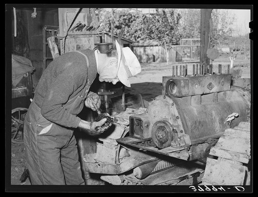 Paul Erickson, owner of forty acres of land in Yuba County, California. He is working on his tractor. He has diversified fruit farm with a federal land bank loan and production credit loan. He does as much of his own pruning, thinning and picking as possible and works out in order to supplement his 