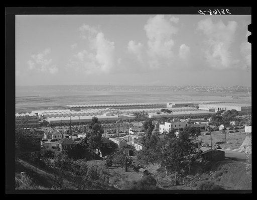 Workers' automobiles parked near the airplane factories. San Diego, California. Providing parking space for automobiles and getting the cars in and out at shift changing time have been big problems