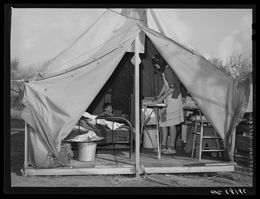 Construction worker's wife ironing in her tent home. Mission Valley, California, about three miles from San Diego
