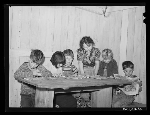 Six children of carpenter from Hobbs, New Mexico, reading the funny papers. This family of eight are living in two small rooms in tourist court because they can find nothing larger at a reasonable price. Corpus Christi, Texas