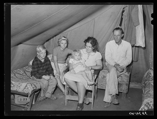 Family of roofer from Oklahoma in their tent home at Corpus Christi, Texas. He is working at the naval air training base. He draws one dollar an hour pay but frequent layoffs because of bad weather makes his average weekly wage small