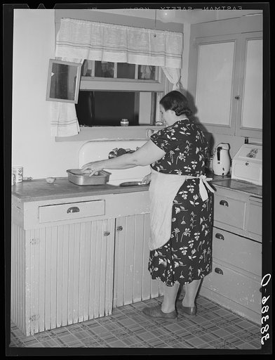 Wife of fruit farmer at her kitchen sink. Placer County, California