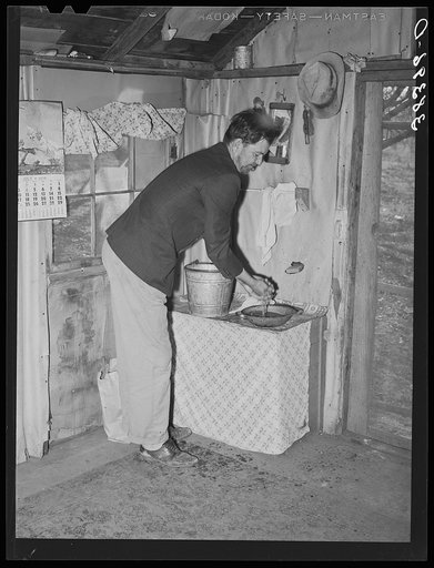 Farmer washing his hands. Placer County, California. This man is from Oklahoma; he came to California first in '35, went back to Oklahoma in '39. Then returned to California. He and his family picked cotton around Bakersfield. He rented his farm in Placer County first and is now buying it. It has th