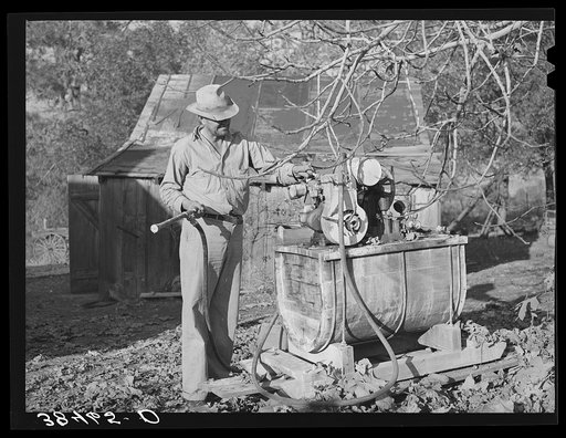 Farmer from Oklahoma who has bought a farm through the Federal Land Bank in Placer County, California. He is looking at his spraying equipment