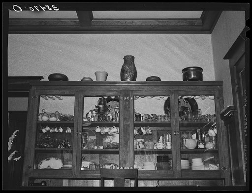 China cabinet in home of fruit farmer. Placer County, California. These fruit specialists have had a high standard of living, are now losing their farms