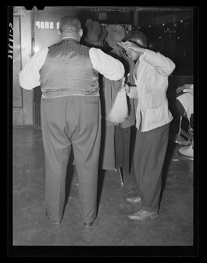 Brushing off a customer in barber shop. Southside Chicago, Illinois