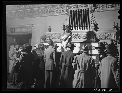 Crowds looking at art exhibit in lobby of Negro theater. Chicago, Illinois