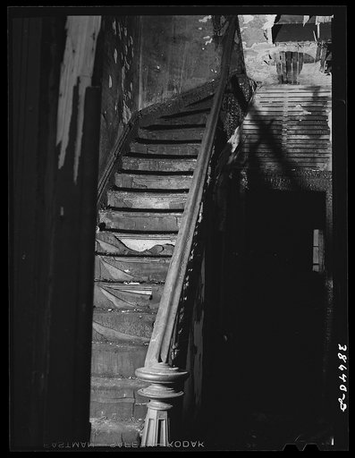 Staircase in hall of apartment buildings formerly rented to Negroes. This house is now vacant after fire. Chicago, Illinois